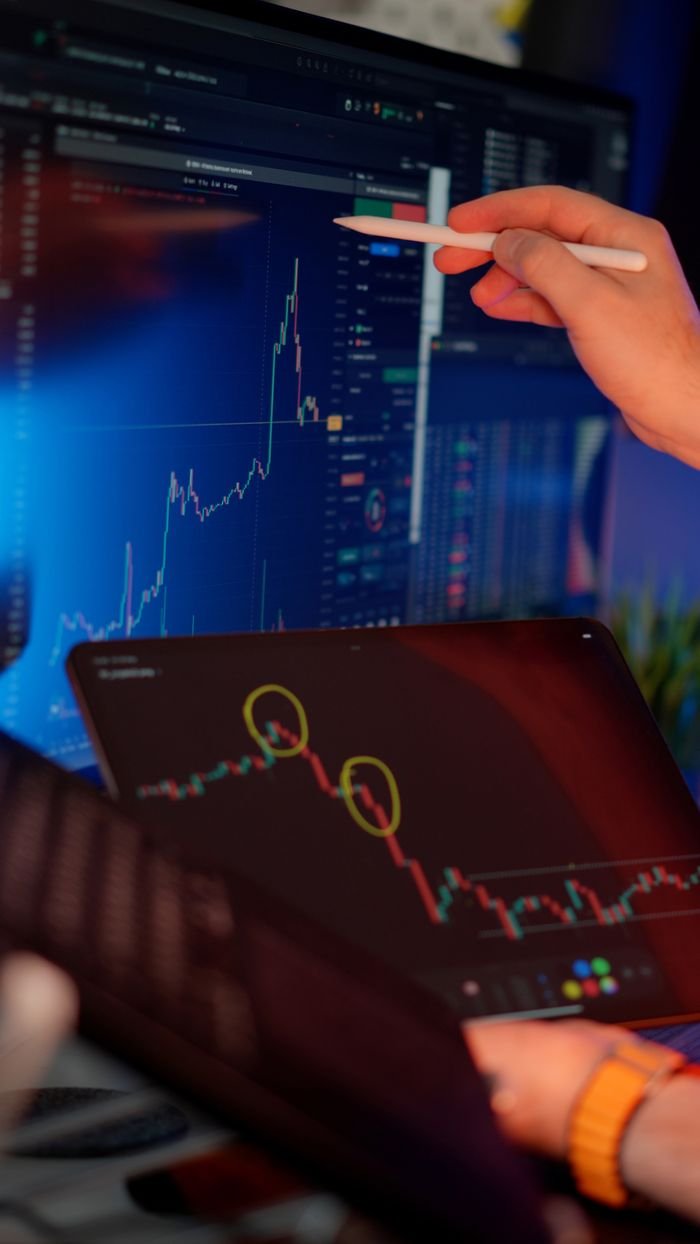 Services A person analyzes cryptocurrency market trends on multiple screens with graphs.